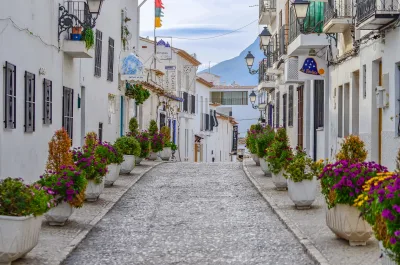 Schilderachtige steeg in Altea, Spanje, versierd met levendige bloemen en witgekalkte gebouwen.