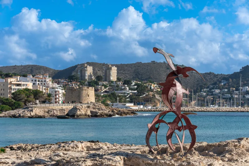 Artistiek beeldhouwwerk op de rotsachtige kust van Moraira met kustlandschap.