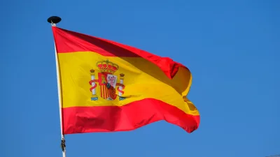 Heldere Spaanse vlag die wappert tegen een heldere blauwe lucht, die nationale trots tentoonstelt.
