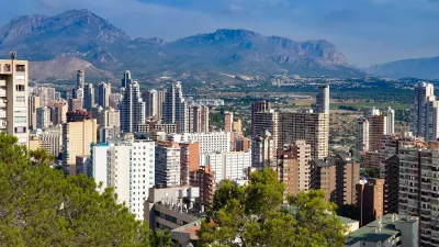 Levendig stadsgezicht van Benidorm met weelderig groen en bergen op de achtergrond.