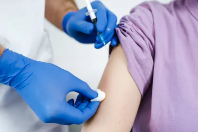 Een oudere man krijgt een vaccinatie in de bovenarm