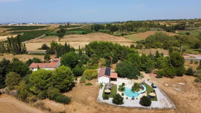 Luchtfoto van een villa op het platteland met weelderig groen en een zwembad.