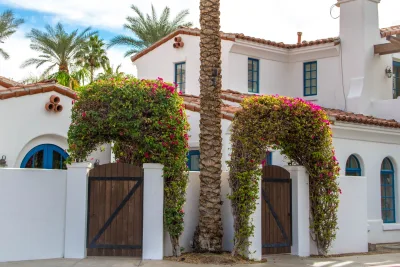 Te-koopbord aan een hek bij een Spaanse woning