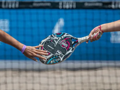 Spelers op een padelbaan met glazen wanden in de buitenlucht