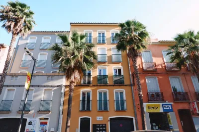 Vibrante appartementgebouwen met palmbomen langs een zonnige straat, perfect voor reis- en stedelijke thema's.