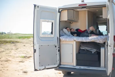 Stel geniet van een gezellig moment binnenin een camper tijdens een roadtrip in Portugal.