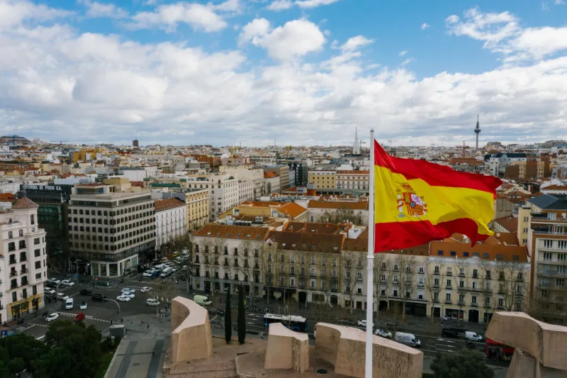 Luchtfoto van Madrid, Spanje, met de Spaanse vlag prominent weergegeven, die de essentie van de stad vastlegt.