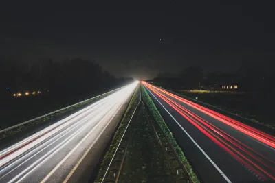 Auto met pech langs de kant van een snelweg met waarschuwingslicht